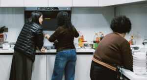 Three women, cooking together.